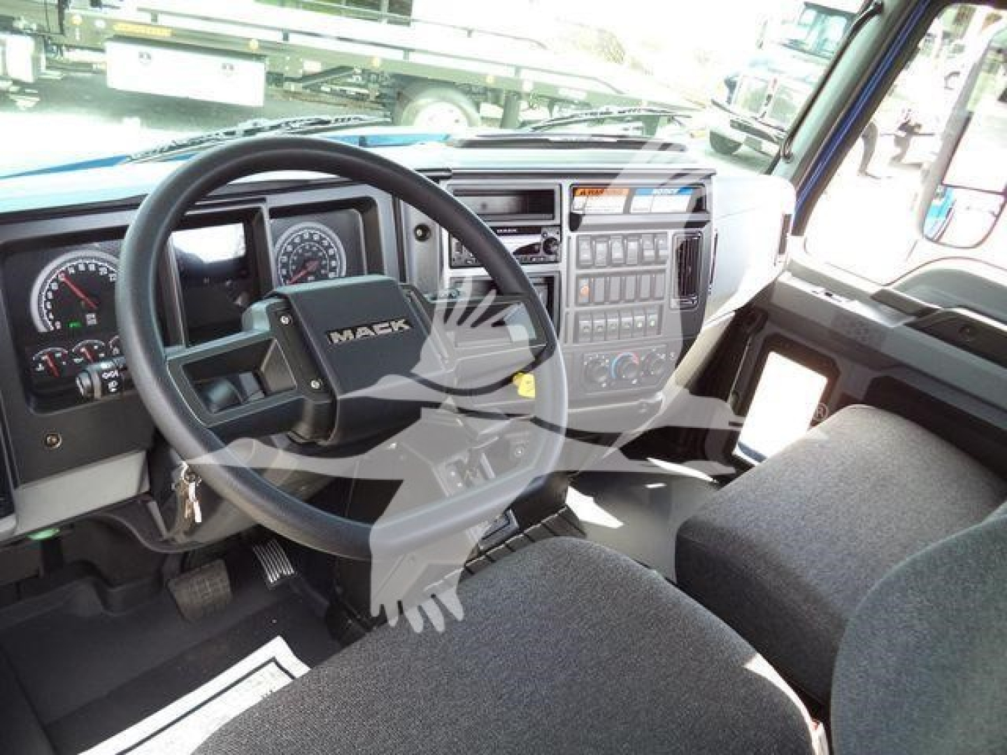 Mack MD6 truck interior showing steering wheel and dashboard with instrument cluster and control panel.