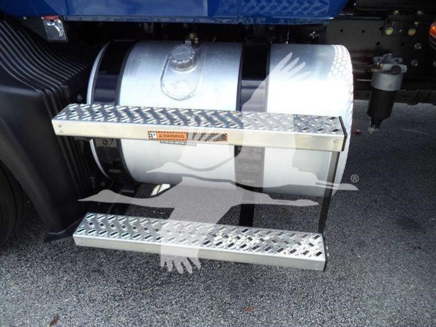 Mack MD6 truck fuel tank and aluminum step/step well in foreground, chrome ladder style steps with diamond plate pattern attached to side of chassis.