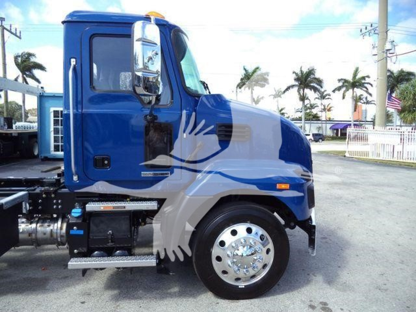 Blue Mack MD6 truck cab side view showing chrome wheel, side step, and fuel tanks.
