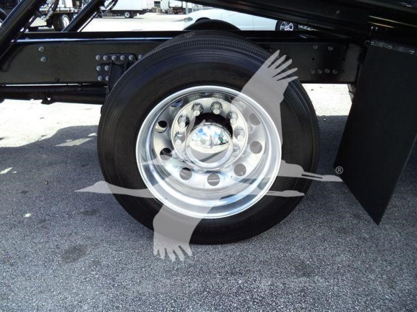 MD6 truck wheel showing chrome hubcap and black tire under chassis, with suspension and frame components visible.
