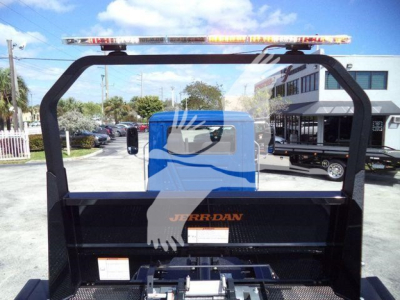 Truck bed back view showing light bar on top, Rollback truck with black steel frame and Jerr-Dan branding on a flatbed cargo area.