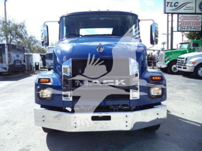 Blue 2027 Mack MD6 truck front view with large grille and bumper in a dealership yard.