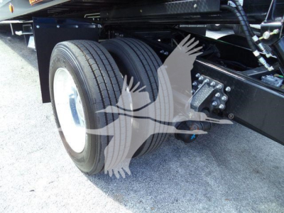 Mack MD6 truck rear dual wheels and suspension showing twin tires and chassis components.