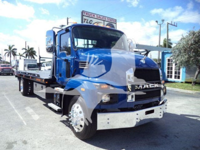 Truck MD6 tow truck with flatbed, blue cab and chrome bumper showing Mack grille and wheel, daytime exterior sale lot.