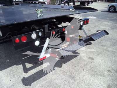 Mack MD6 rollback truck rear showing platform and underride with service lighting and steps.