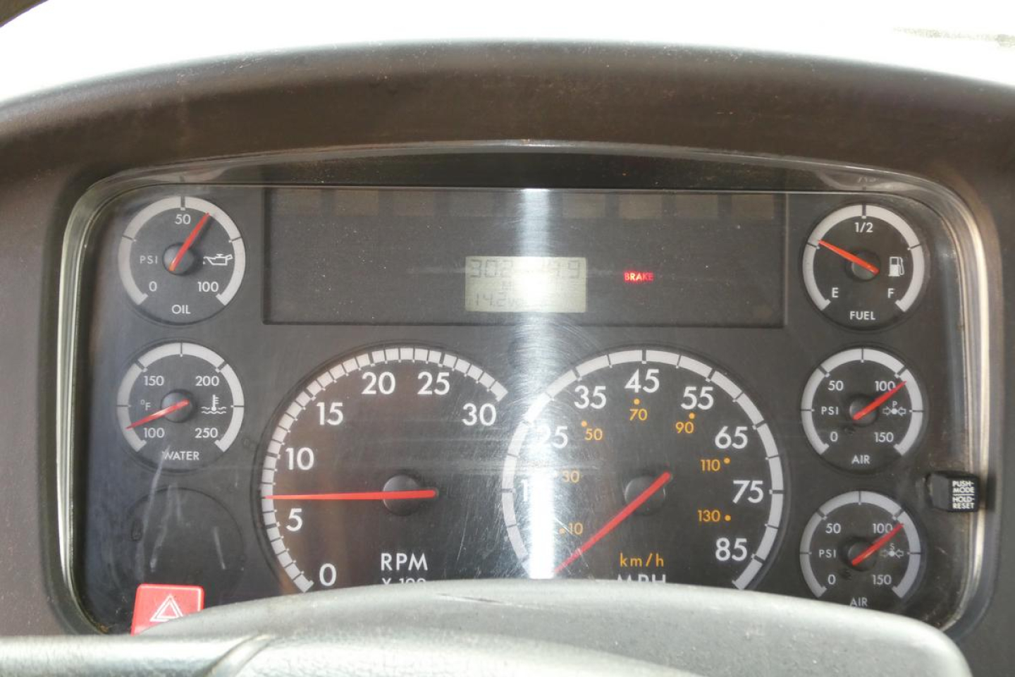 Dashboard view of 2006 Freightliner M2-106 showing rpm gauge, speedometer, warning lights, and various gauges in a truck cab.