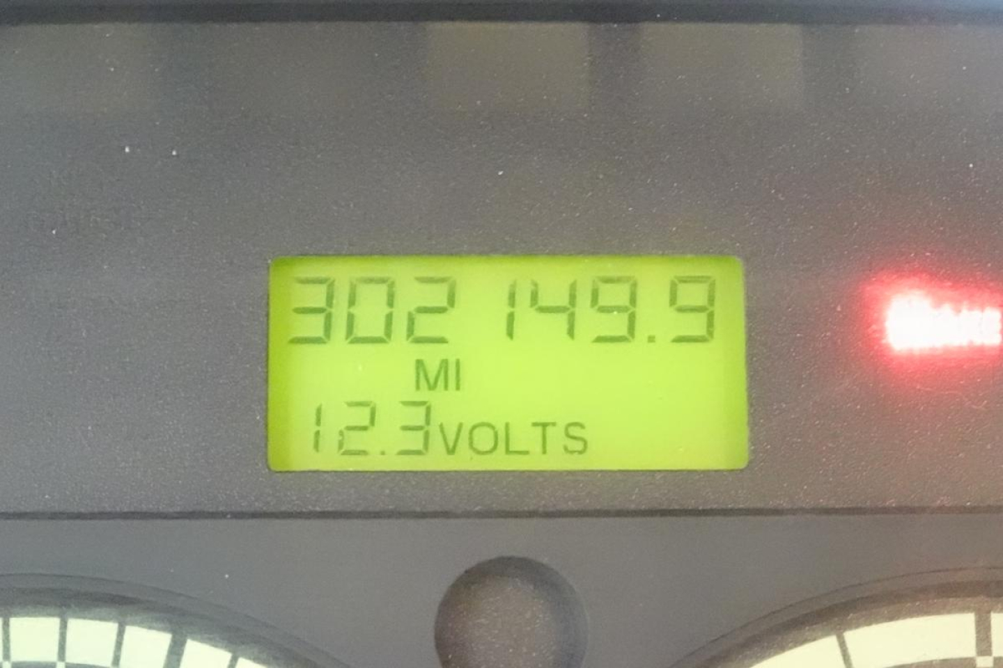 Dashboard display showing 302149.9 MI and 12.3 VOLTS on a Freightliner M2-106 instrument cluster.
