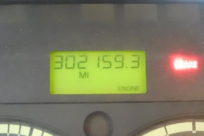 Dashboard display showing odometer reading 302159.3 miles and 'ENGINE' label with green backlight.