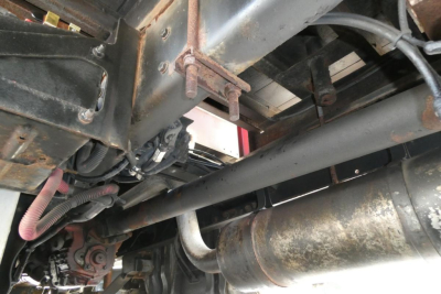 Truck chassis underside showing exhaust pipe and structural frame components.