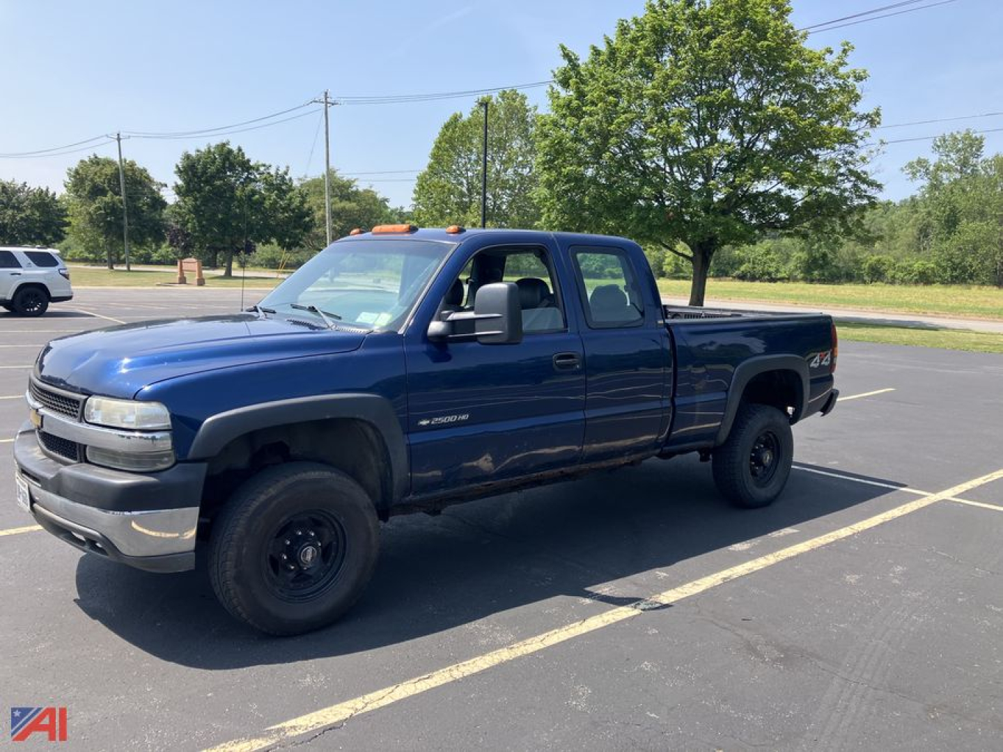 2002 Chevrolet Silverado 2500HD extended cab pickup truck in blue parked in lot with trees in background