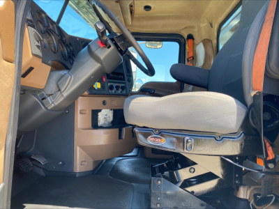Cab interior of a 2016 Mack GU533 rolloff truck showing steering wheel, dashboard, and driver's seat.