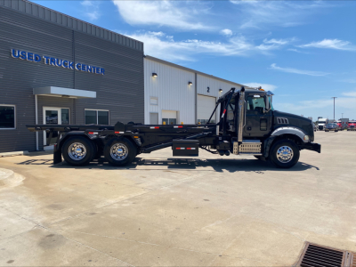 2016 Mack GU533 roll-off truck side view showing extended flatbed and rear wheels