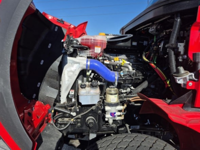 Western Star 47X engine bay showing blue hose, coolant reservoir, and auxiliary power components in front of the cab.