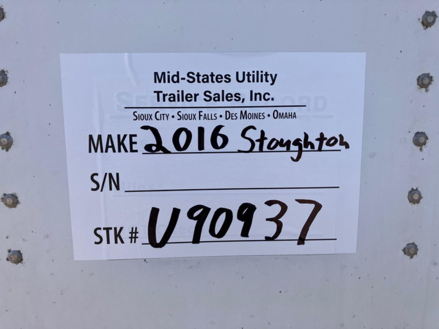 Tag on trailer showing Mid-States Utility Trailer Sales, Inc. with handwritten 'MAKE 2016 Stoughton' and stock number V90937.