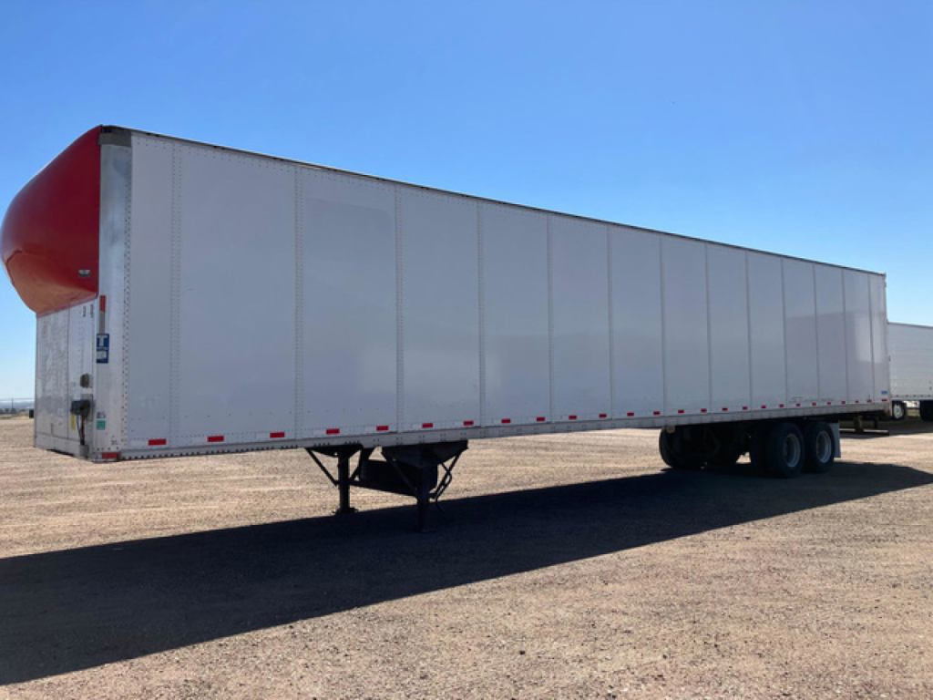 Trailer side view showing Stoughton van with curved red nose cone at front, white aluminum siding, tandem axles, landing gear in foreground, no visible lettering.