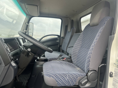 Truck cabin interior of a 2023 Chevrolet 4500 HD flatbed showing front seats and steering wheel.