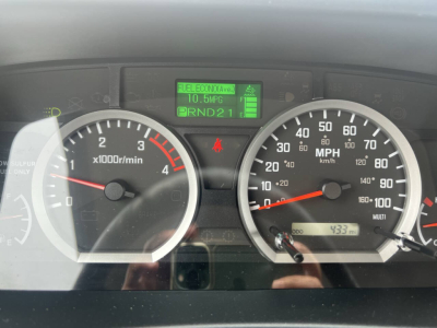 Gauge cluster of a 2023 Chevrolet 4500 HD showing tachometer, speedometer, and a green digital display with fuel economy 10.5 MPG, PRND21 indicator, and odometer area.