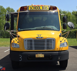 School bus front view showing chrome grille, yellow body, side mirrors, and school bus sign on top.