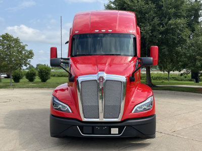 Kenworth T680 truck with red cab from front view showing grille, headlights, and mirrors.