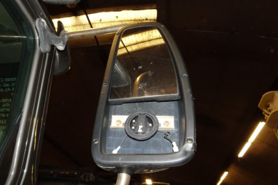 Mirror view inside cabin showing circular dial and mounting hardware on a truck side mirror assembly, part of a 2004 International 9400 pickup.