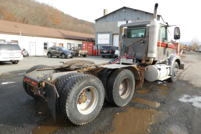 Truck rear view showing chassis and dual rear axles with mud flaps and hitch; semi-truck cab with exhaust stack and sleeping area.