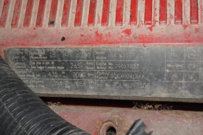 Identification plate showing engine and model details: ISX 435ST, engine hours and numbers, serials, and various specs with worn labels.