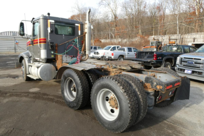 Truck chassis showing rear axles and fifth wheel mount; cab with exhaust stack; no visible branding readable on image