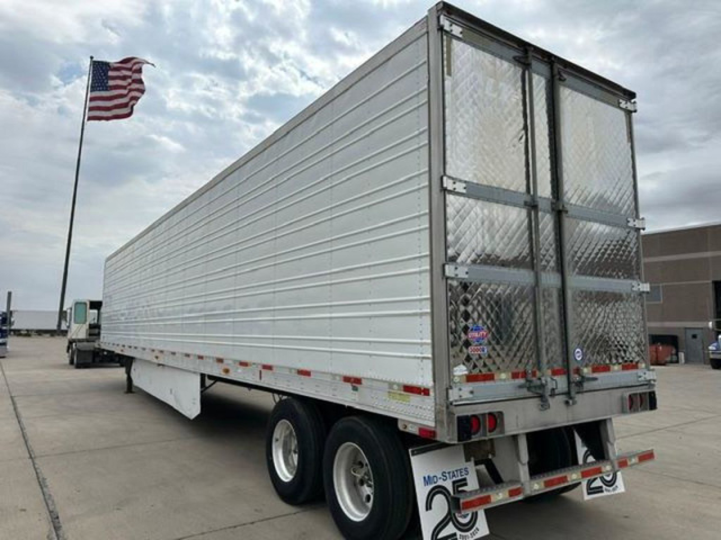 Trailer side view showing a 2016 refrigerated utility trailer with aluminum siding, dual rear doors, and Missouri plates; stock number U90976.