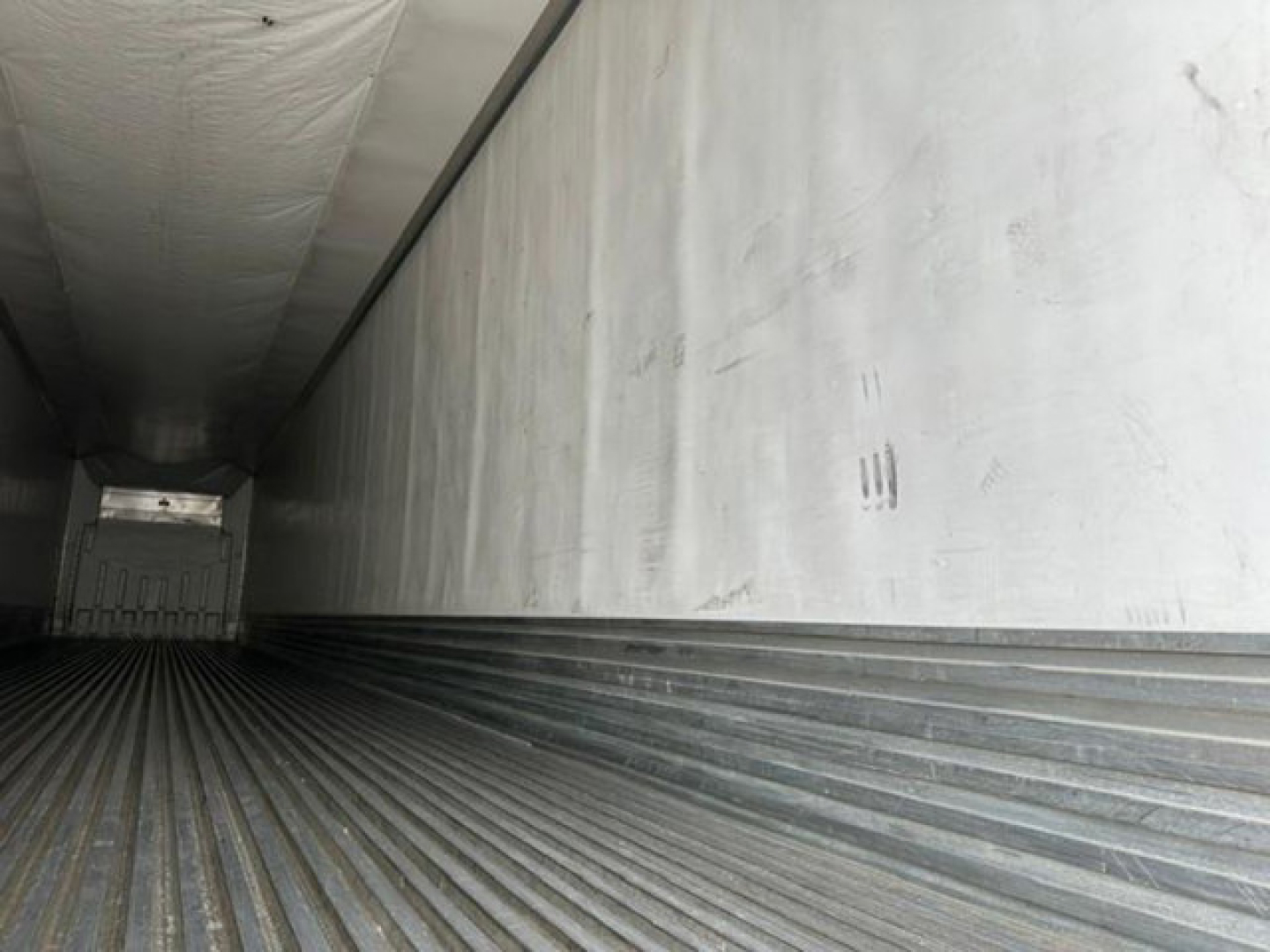 Trailer interior showing ribbed floor and side walls of a 2016 refrigerated trailer (reefer) with open rear door.