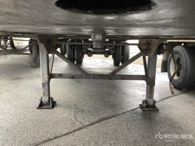 Underneath view of a used trailer landing gear and frame with jacks and support beams visible