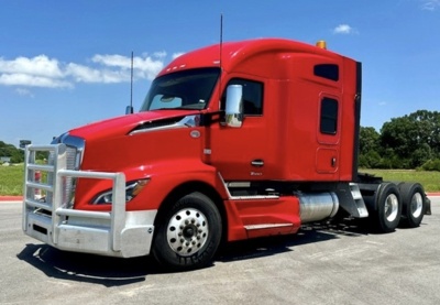 Red Kenworth T680 truck with a chrome grille guard, sleeper cab, and dual rear axles. Front bumper, hood vents, and side mirrors visible with no legible labels in view.