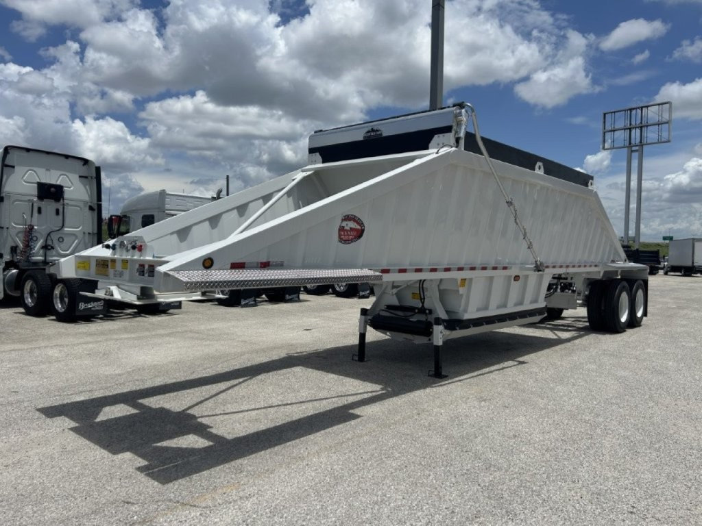 Trailer in a parking lot showing CTS BDT-40 spring dump trailer with triangular frame and side panels, no slip sheets notice.