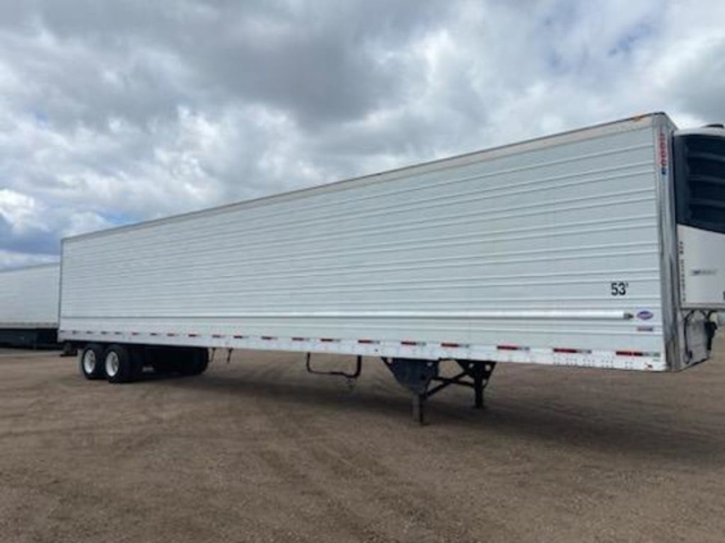 Trailer side view showing 53' refrigerated trailer with closed aluminum body and landing gear.