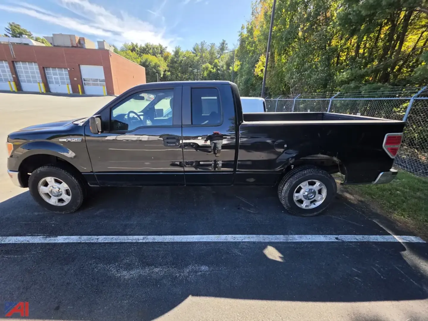 Ford F-150 pickup truck side view showing crew cab and long bed in black paint.