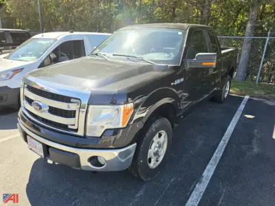 2013 Ford F-150 pickup truck in a parking lot, black exterior, chrome front bumper and grille, four-door crew cab, VIN 1FTFX1EFXDFB92197 visible on listing, 4x4 category.