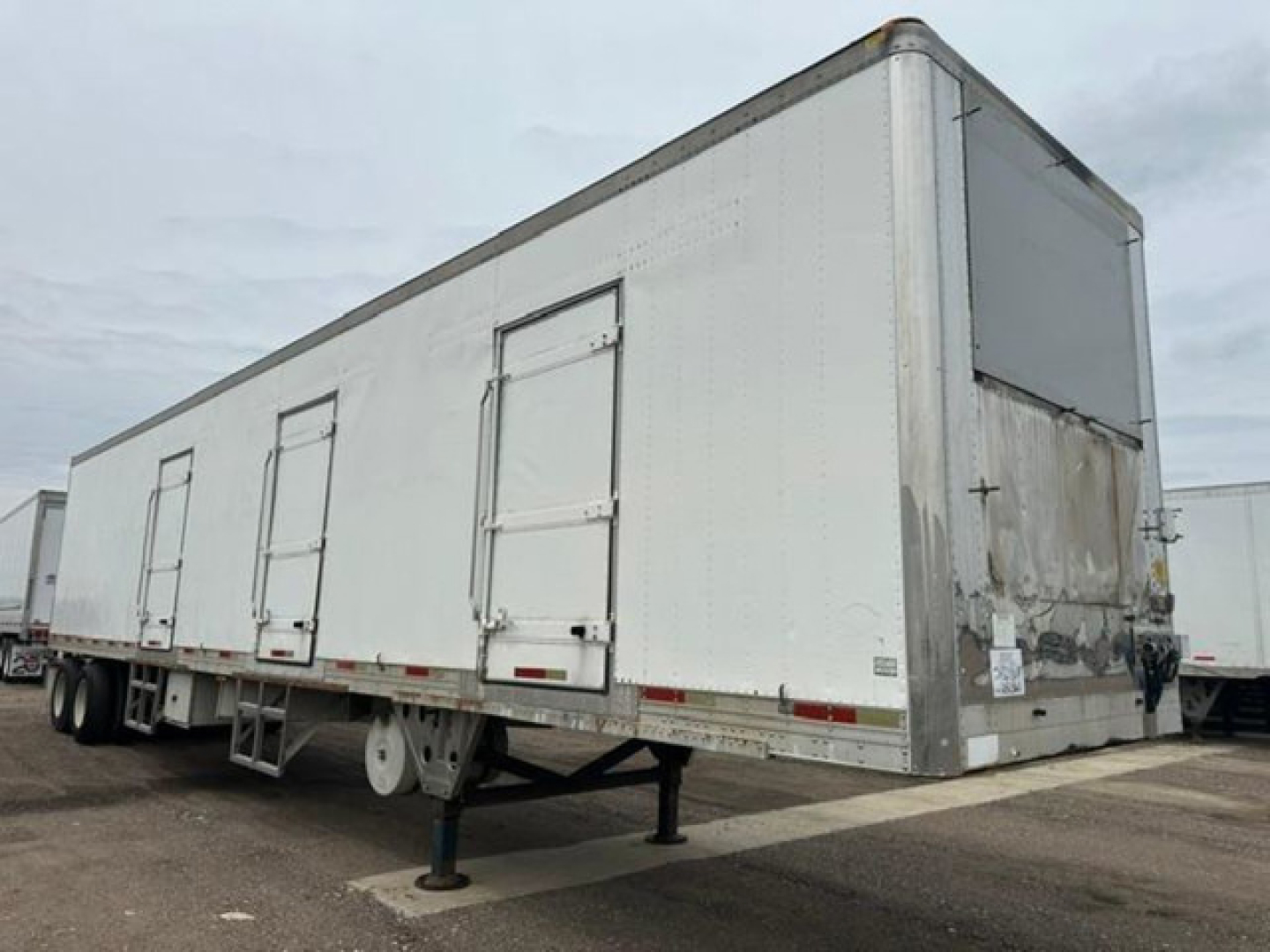 Trailer side view of a 2005 utility refrigerated trailer with multiple doors and a raised nose; stock number U90860, VIN 1UYVS24865M567309.
