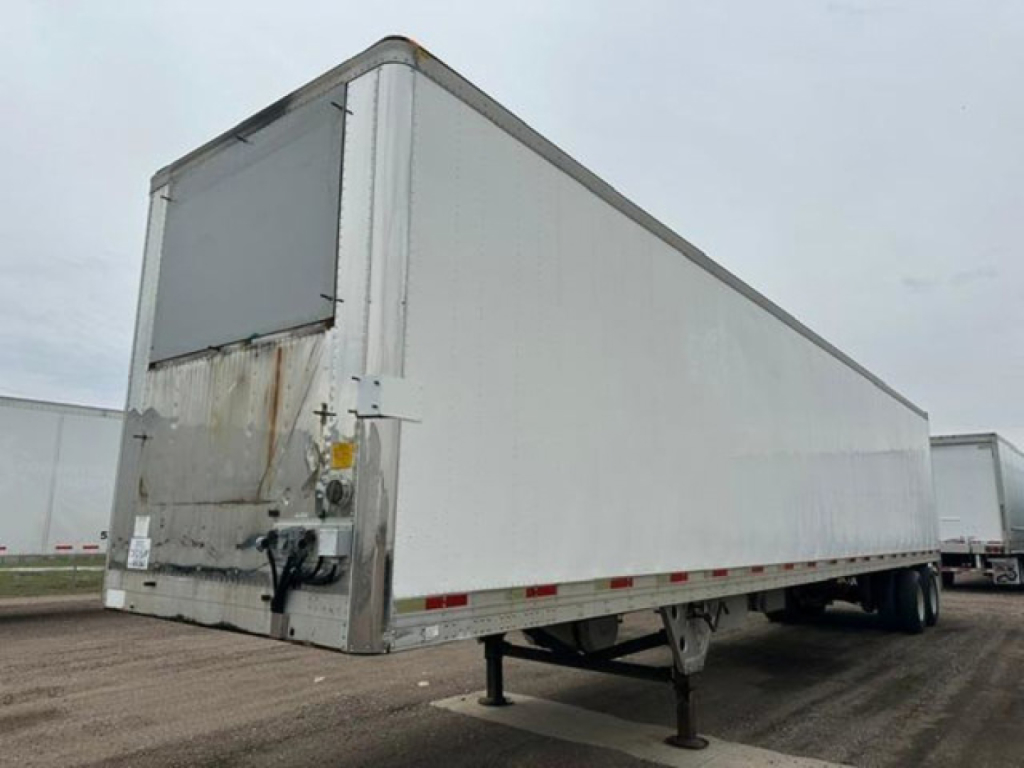 Utility reefer trailer side and rear showing metal box with landing gear extended and damaged rear door area.