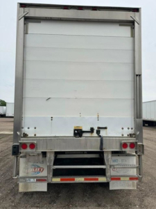 Rear view of a 2005 utility refrigerated trailer showing opaque white roll-up doors and lower bumper with reflectors.