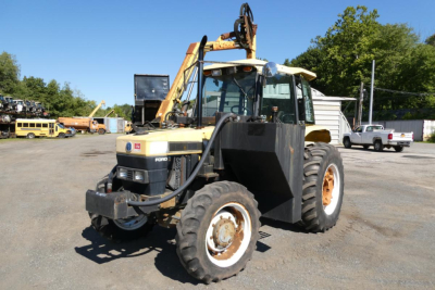 Front-left view of a 1996 Ford 6640 tractor with a front loader, large tires, and hydraulic arms in a gravel lot.