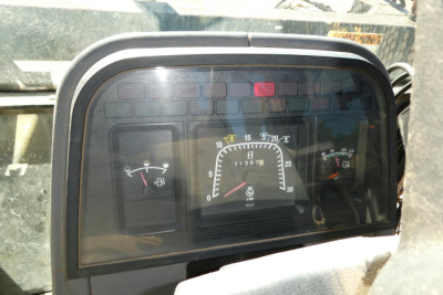 Intrument cluster of Ford 6640 tractor showing gauge panel with speedometer, tachometer, and warning lights; dash in view.