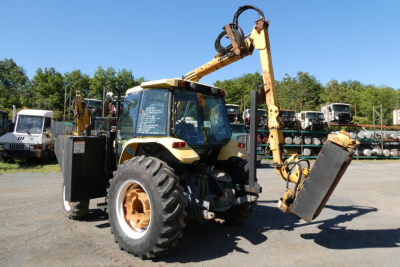 Ford 6640 tractor with front loader attachment in a used machinery lot, visible tires, cab, and lifting arm.