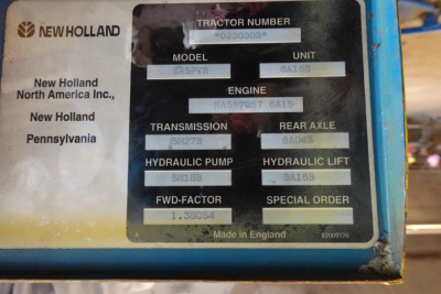 Label plate on New Holland tractor showing model, engine, transmission, rear axle, hydraulic lift, forward factor, and special order specs.