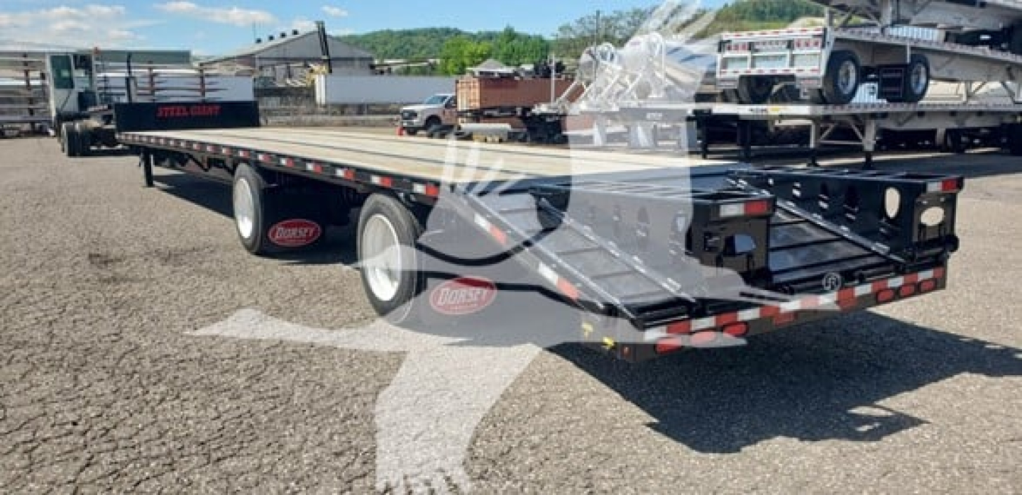 Trailer showing flatbed beavertail with dual rear wheels and reflective safety lights.
