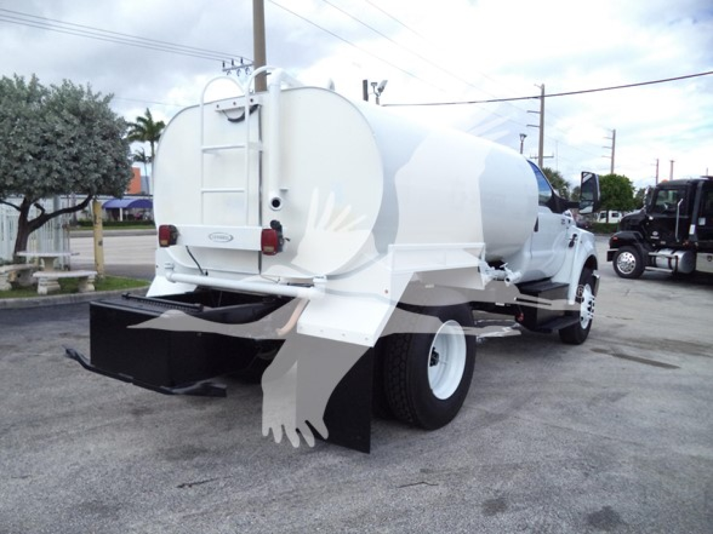 Rear/side view of a white 2017 Ford F650 vacuum or water tanker truck with rear hoses and white dual rear wheels.