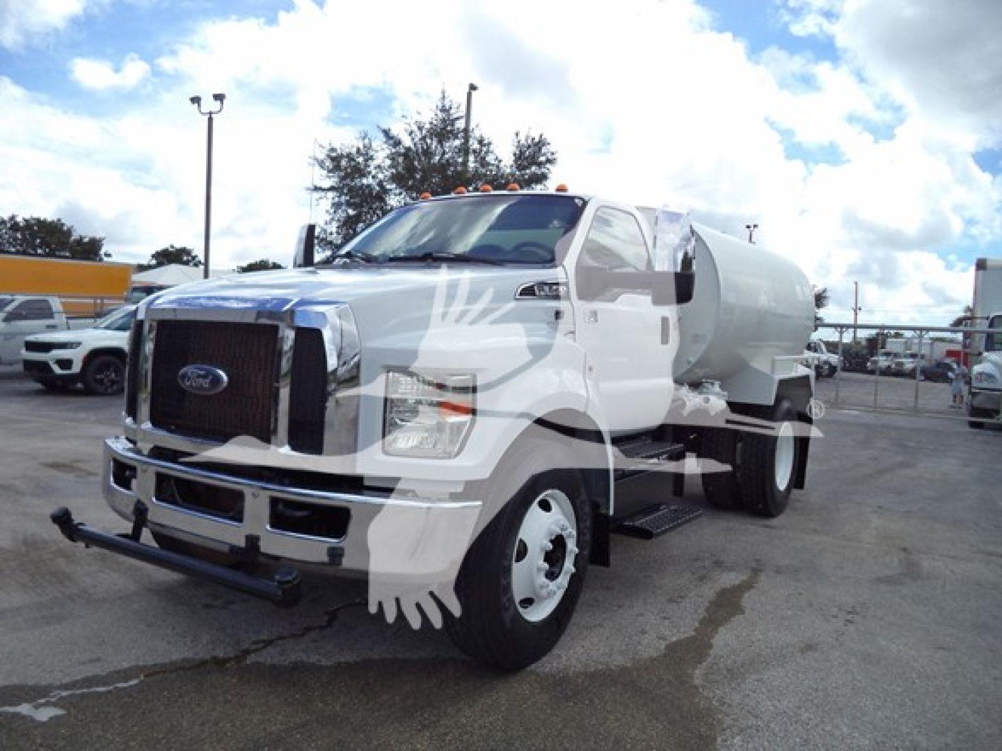 Fuel or water tanker truck view showing front grille with Ford emblem and front bumper, large cylindrical tank mounted on chassis, headlights, and side mirrors.