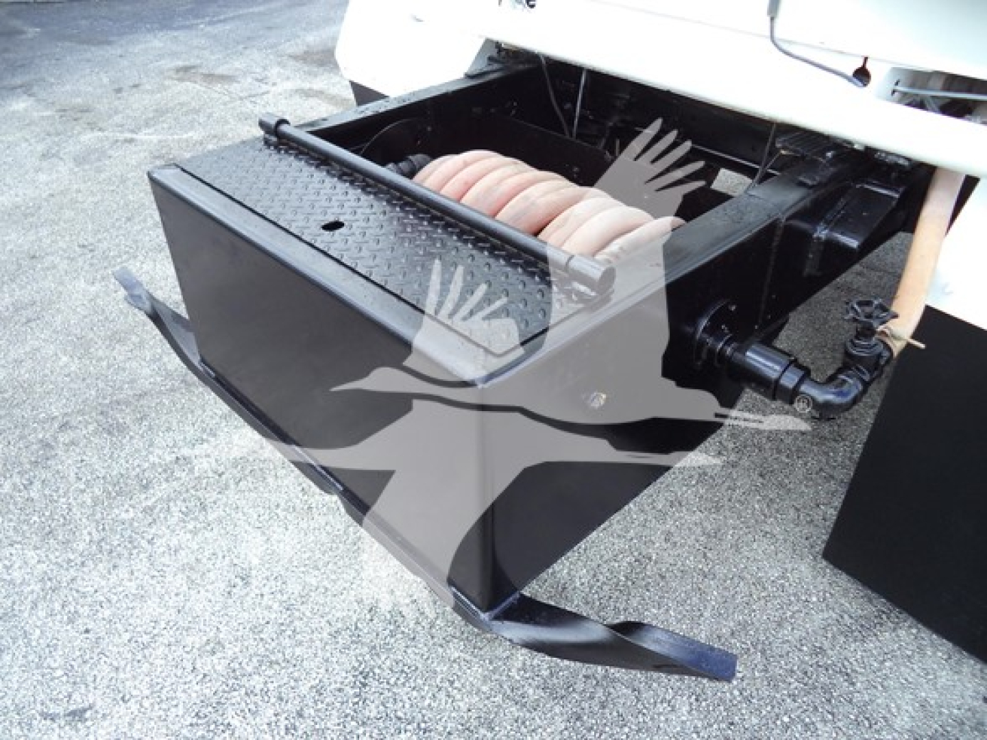 Truck bed with large black box and compressor coils; no legible alphanumeric labels visible on the image.