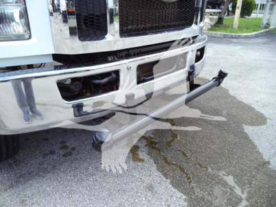Ford F-650 front bumper with chrome grille and aftermarket tubular side step shown.