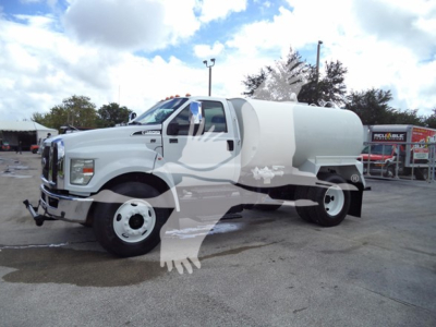 2017 Ford F650 medium-duty truck with a water tank, side view showing cab and tanker body, white exterior.