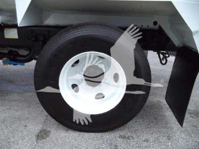 Ford F650 wheel and undercarriage view showing single rear dual wheel, white steel rim and tire, mud flap visible