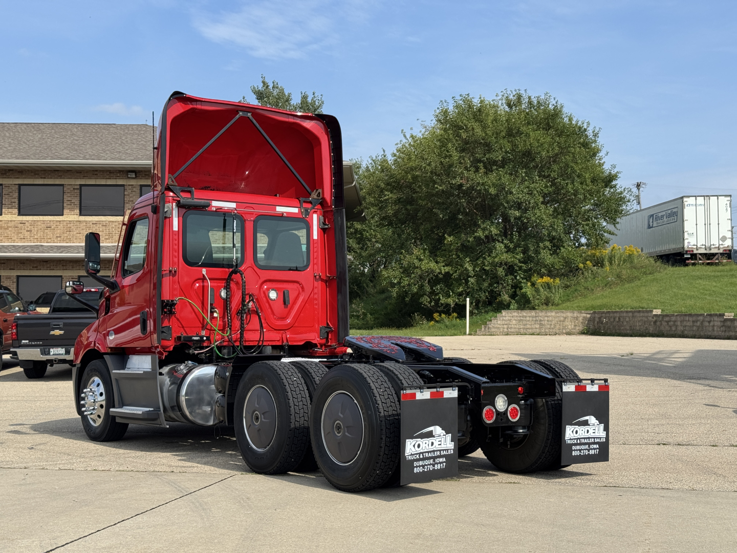 Truck rear view showing chassis and fifth wheel area of a red 2022 Freightliner Cascadia 116 day cab in-use condition.